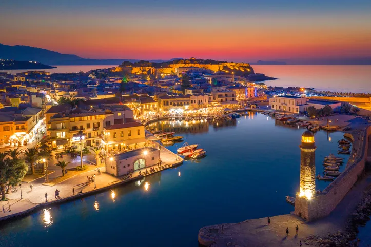 Rethymno velencei kikötője és világítótornya Krétán, hangulatos esti kivilágításban, naplemente után.