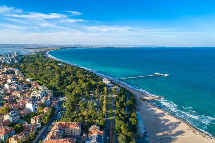 Légi felvétel a burgaszi tengerparti parkról, a homokos strandról és a Fekete-tengerbe nyúló mólóról, Bulgária.