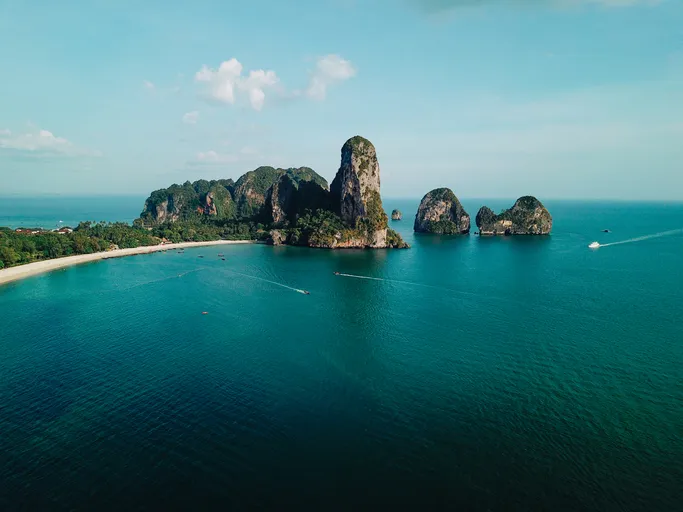 Légi felvétel a thaiföldi Krabi partjairól, a tengerből kiemelkedő meredek mészkősziklákkal és hajókkal.