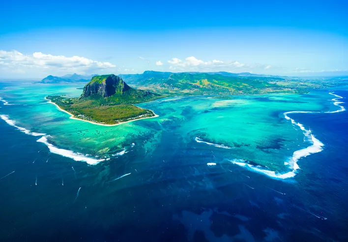 Madártávlati kép Mauritius szigetéről, a Le Morne Brabant heggyel és a tenger alatti vízesésként ismert különleges optikai csalódással.